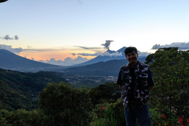 istock Young man with view of volcano during sunset in Guatemala 1273402943