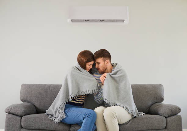 istock Freezing couple in cool room cuddling in plaid 1273403885