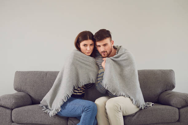 istock Freezing couple in cool room cuddling in plaid 1273403886