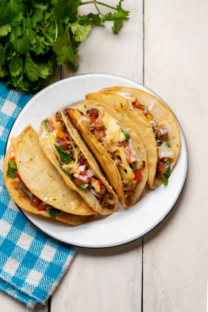 istock Mexican hard-shell tacos with meat and fresh sauce on white background 1273404648