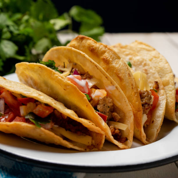 istock Mexican hard-shell tacos with meat and fresh sauce on white background 1273404766