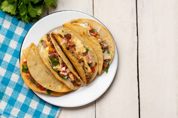 istock Mexican hard-shell tacos with meat and fresh sauce on white background 1273405210