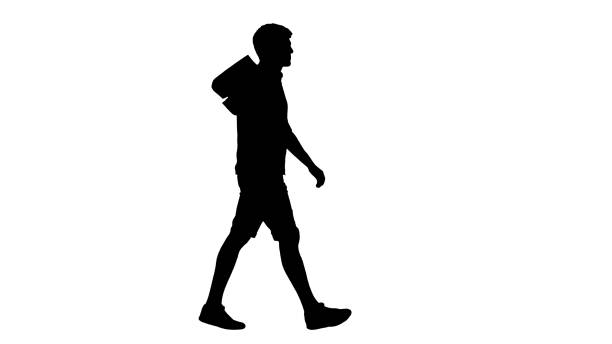 Wide shot. Side view. Silhouette Handsome man in casual clothes walking with shopping bags looking at camera. Professional shot in 4K resolution. 047. You can use it e.g. in your medical, commercial video, business, presentation, broadcast