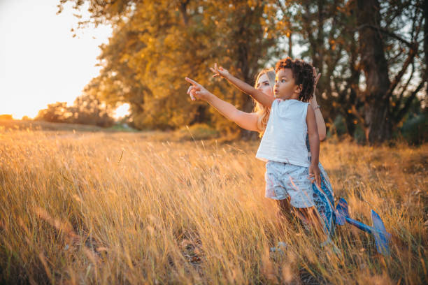 istock Mother Holding her Son, Pointing a Finger Somewhere in Horizon 1273418116