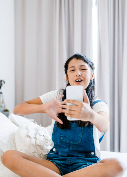 istock Girl using smart phone in bedroom at home 1273422732