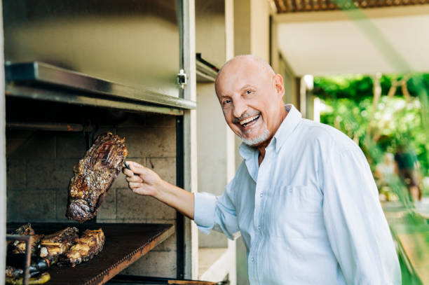 istock Senior man grilling meat in backyard 1273422895