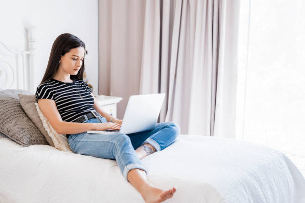 istock Young woman using laptop in bedroom 1273423510