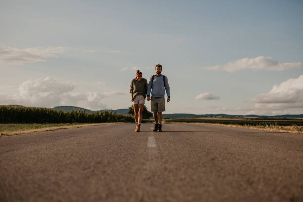 istock Young backpackers holding arms and walking outdoors 1273425846