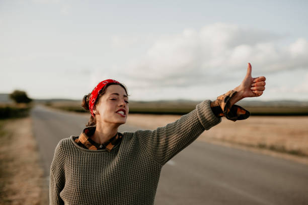 Life's a journey, not a destination Young beautiful female hichhiker looking for an adventure. hitchhiking stock pictures, royalty-free photos & images