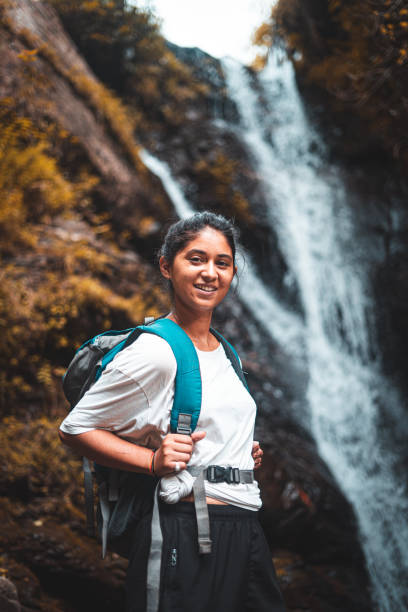 Young girl in white dress enjoying the beautiful waterfall view. Freedom and travel. Young girl in white dress enjoying the beautiful waterfall view. Freedom and travel. india tourism stock pictures, royalty-free photos & images