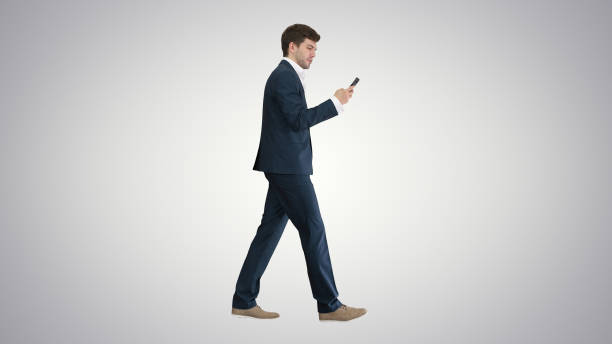 istock Serious businessman using phone voice dial while walking on grad 1273428551