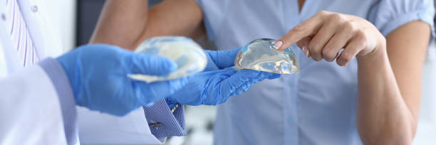 girl in clinic touches silicone breast implant - aging process middle women men imagens e fotografias de stock