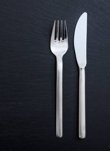 istock Cutlery isolated on black background, vertical top view 1273432223