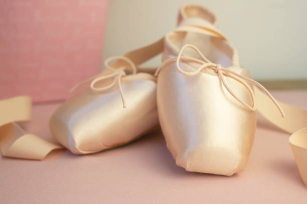 istock New pink pointe shoes for ballet on a pink background. 1273433507