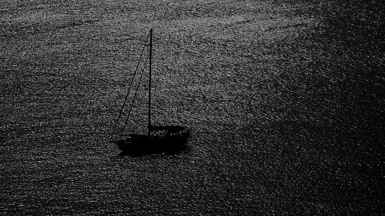 scenic of silhouette boat in the sea with black and white image in minimalist concept