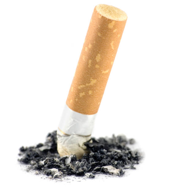istock Cigarette butt and ash pile macro closeup, quitting smoking concept, isolated vertical large detailed studio shot 1273434589