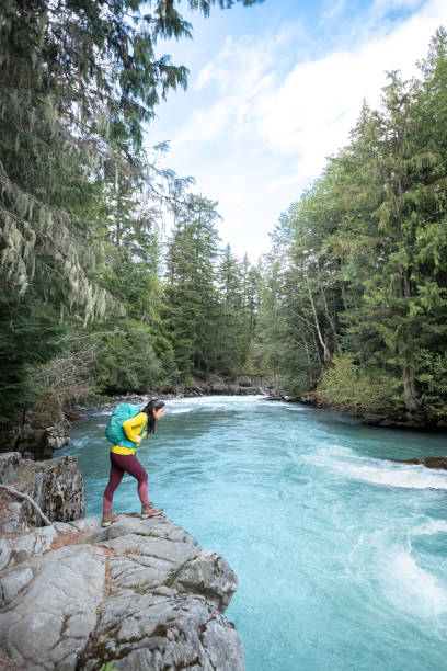 istock Young, Eurasian Woman Looking at Turquoise River from Rocky Ledge 1273438880