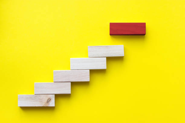 istock Red wooden block on yellow. Business planning, Risk Management, Solution, leader, strategy, different and Unique Concepts. Wood block stacking as step stair. Concept for business growth success process, Copy space. 1273439507