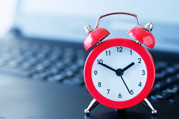 istock Red alarm clock on a computer keyboard, with a blurred background and a shallow depth of field. 1273441854