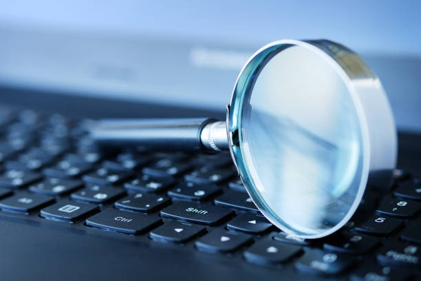 istock Magnifier on a computer keyboard, with a blurred background and shallow depth of field. 1273441855