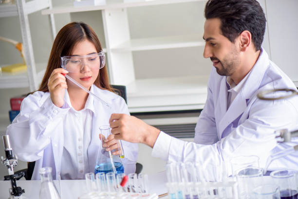 istock Attractive happiness scientist lab technician assistant analyzing sample in test tube at laboratory. Medical, pharmaceutical and scientific research and development concept. 1273445032