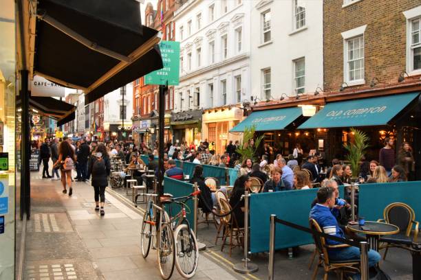 Crowd of people at bars and restaurants in Soho, London London, United Kingdom - September 11 2020: Social distancing outdoor street seating at bars and restaurants on Old Compton Street, Soho with crowd of people covent garden photos stock pictures, royalty-free photos & images