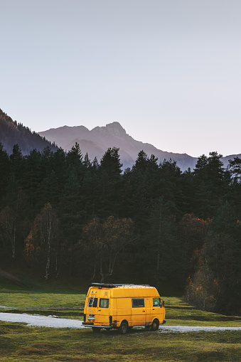 Travel van yellow camper road trip vacations in mountains summer family journey vanlife weekend caravan camping