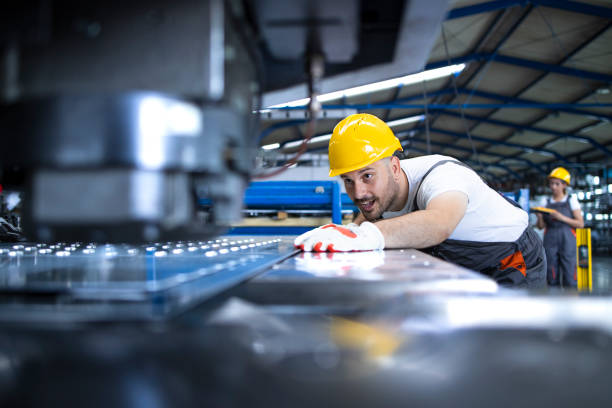 istock People working in factory. Operating industrial machine. 1273452265