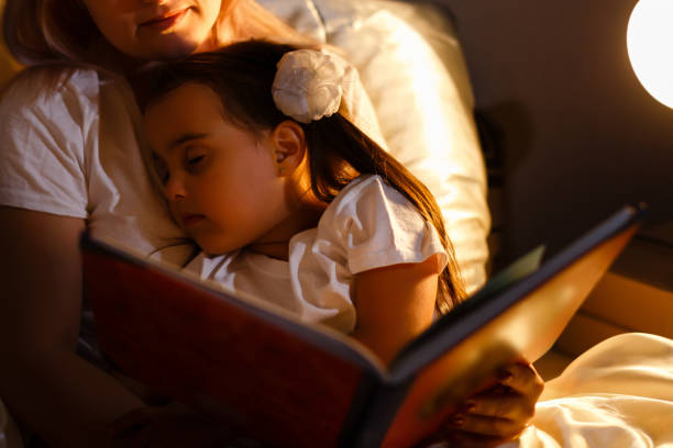 istock Little daughter fell asleep at mom while reading book 1273452717