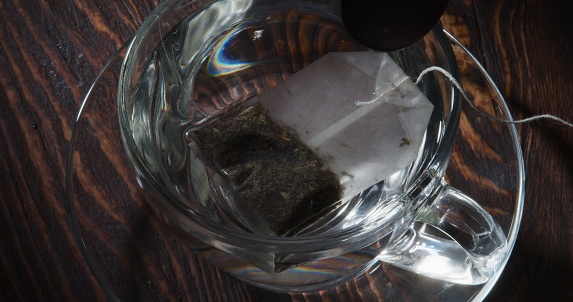 Making a cup of green tea with a tea bag. Close-up