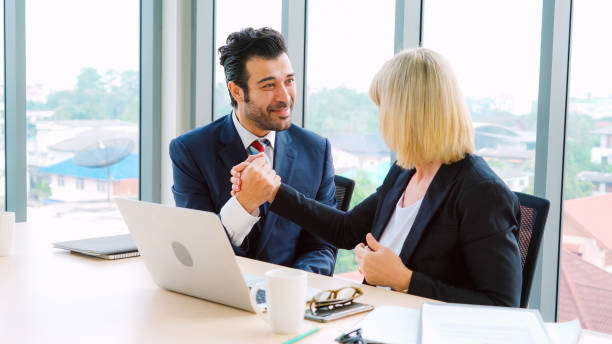 istock Two happy business people celebrate at office 1273458626