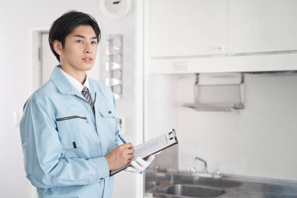 operaio giapponese che controlla l'attrezzatura nella stanza - tuta da lavoro foto e immagini stock