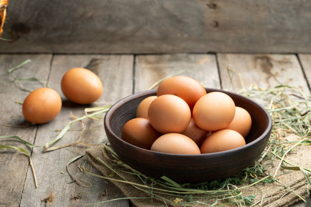 istock Fresh chicken eggs in a clay bowl on the hay. 1273460975