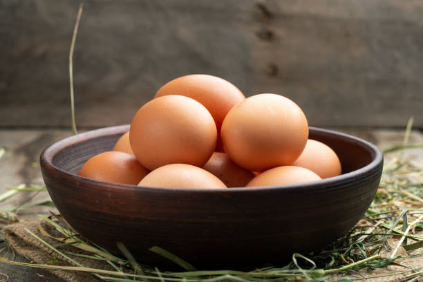istock Fresh chicken eggs in a clay bowl on the hay. 1273460996