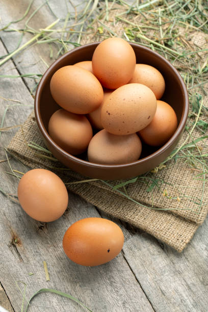istock Fresh chicken eggs in a clay bowl on the hay. 1273461090