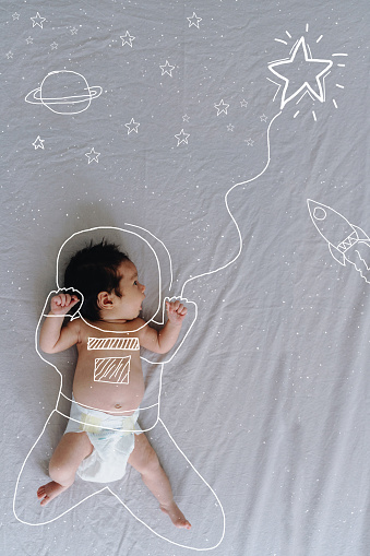 Photo of little baby, with a doodle art showing future astronaut.