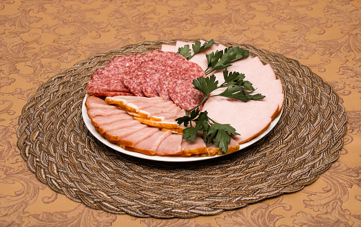 Meat and sausage on a plate on a table, food