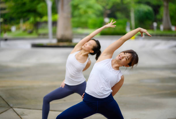 Fitness Asian woman doing yoga exercise and relax with sportswear in city public park. Healthy lifestyle concept.