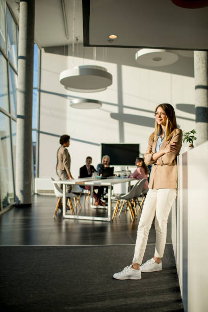 istock Casual young woman in a busy modern workplace 1273464901