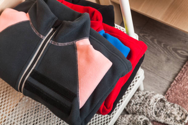 Stacked colorful fleece jackets laying on a shelf
