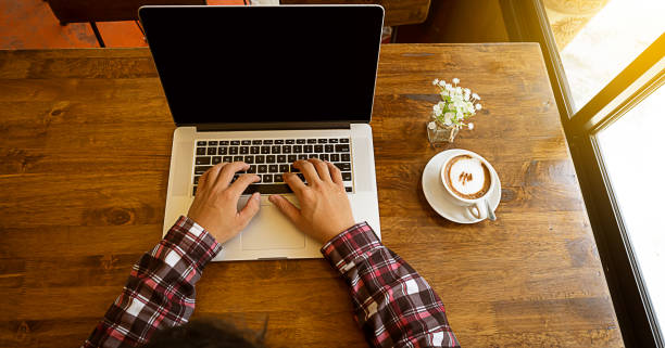 istock A business man working on a laptop while in a coffee shop on vacation top view 1273470841