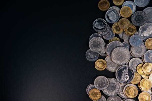 monety franka szwajcarskiego leżą na ciemnym tle. - swiss currency coin swiss francs swiss coin zdjęcia i obrazy z banku zdjęć