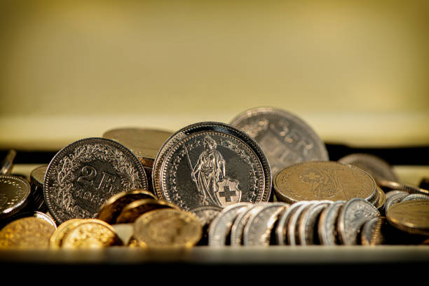 monety franka szwajcarskiego leżą na lekkim tle. - swiss currency coin swiss francs swiss coin zdjęcia i obrazy z banku zdjęć