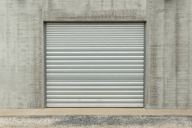 istock Closed metallic garage door in a grey industial wall 1273472875