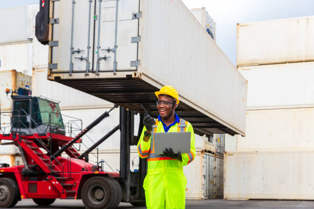 istock Foreman is controlling air or sea freight. Foreman works with laptop computer radio to communicate with forklift drivers. 1273473156