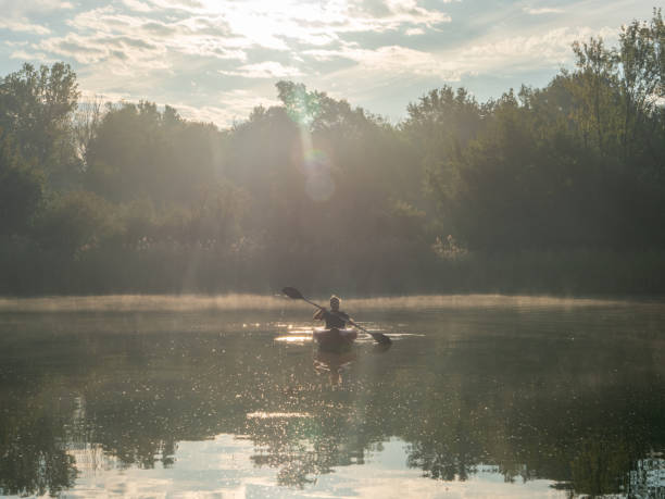 istock Man canoeing on river at sunrise 1273474059