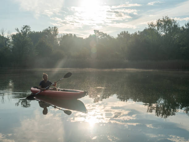istock Man canoeing on river at sunrise 1273474069