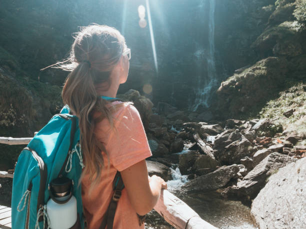 istock Woman contemplating waterfall in Switzerland 1273474087