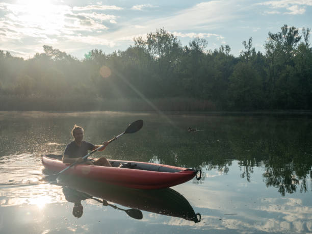 istock Man canoeing on river at sunrise 1273474158