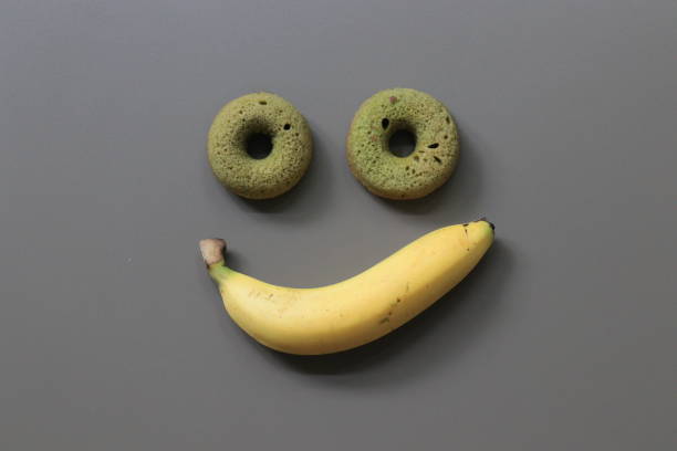 istock 2 Donuts and 1 Banana on Brown Background 1273474252